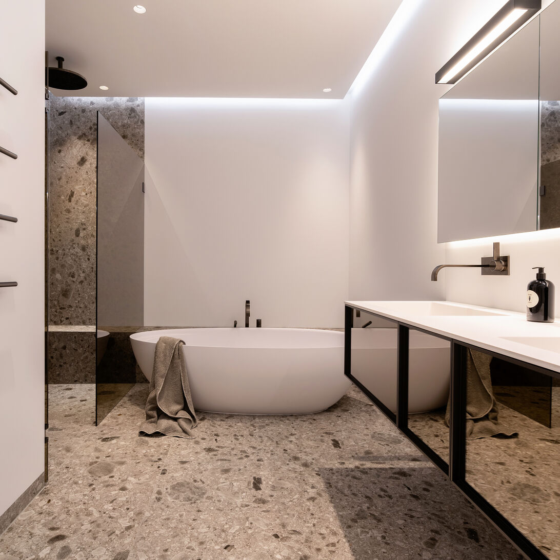 Ein stilvolles Badezimmer mit freistehender Badewanne und großen Fliesen. Dezente Beleuchtung und klare Linien sorgen für eine ruhige, entspannende Atmosphäre. Ein stilvolles Badezimmer mit freistehender Badewanne und großen Fliesen. Dezente Beleuchtung und klare Linien sorgen für eine ruhige, entspannende Atmosphäre.