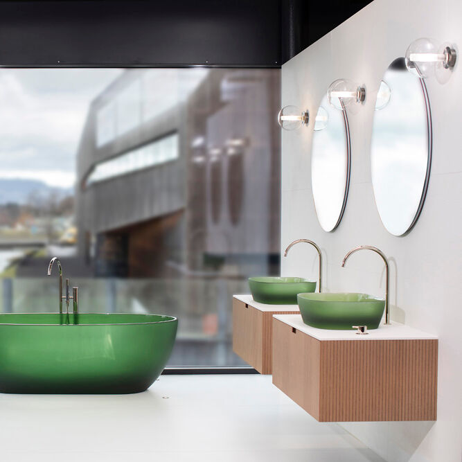 Modernes Badezimmer mit grüner Badewanne und Waschbecken. Große Fenster bieten Ausblick auf moderne Architektur und Landschaft. Elegante Beleuchtung. Modernes Badezimmer mit grüner Badewanne und Waschbecken. Große Fenster bieten Ausblick auf moderne Architektur und Landschaft. Elegante Beleuchtung.