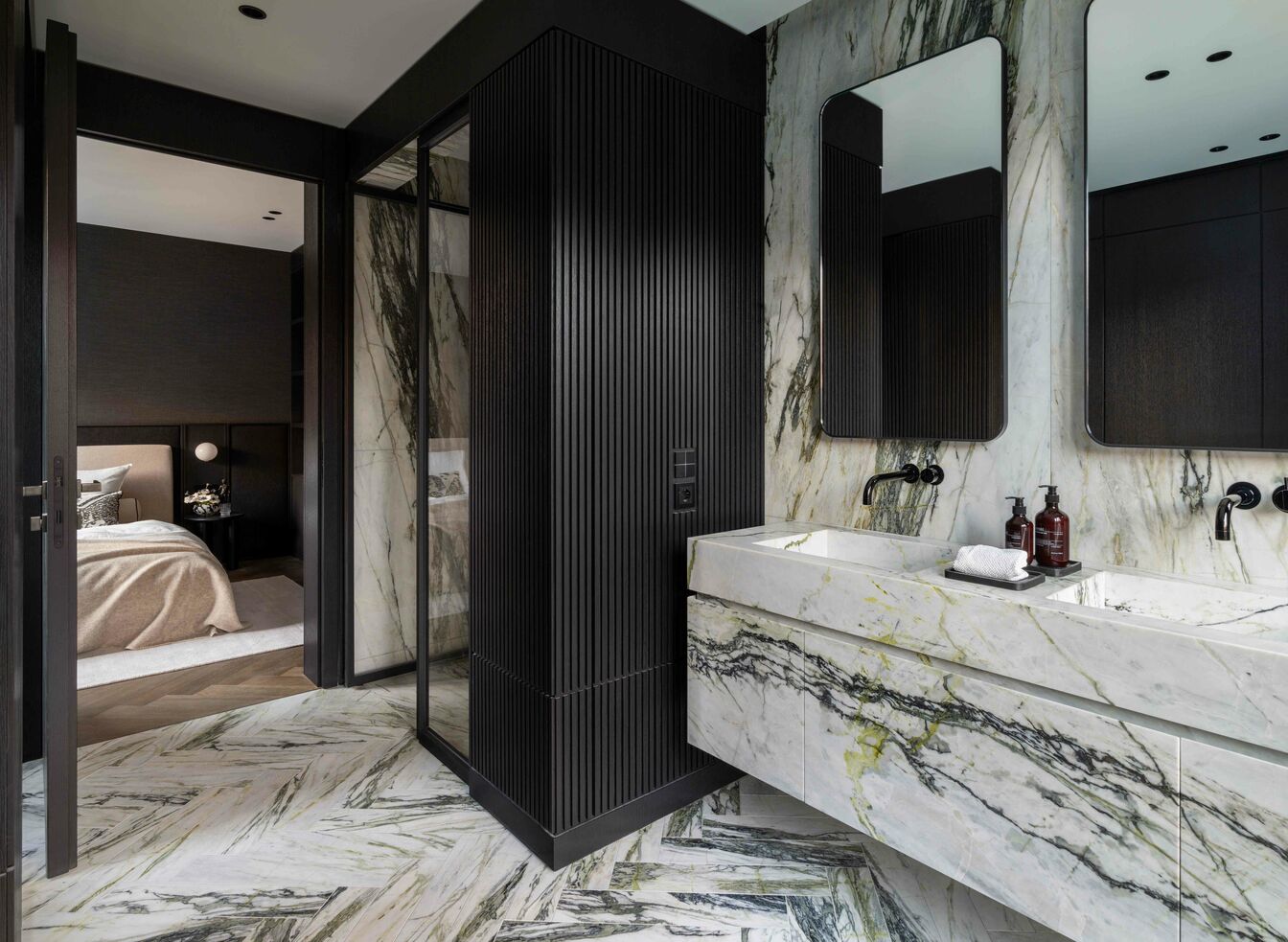 Modernes Badezimmer mit marmorierten Oberfl&auml;chen und Doppelwaschtisch. Schwarze Akzente und Armaturen, Glasduscht&uuml;r, und ein &Uuml;bergang zum Schlafzimmer schaffen ein harmonisches Design.